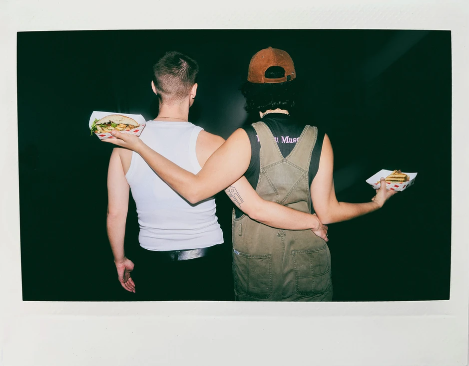 Two People, One Person Holding Two Sandwiches